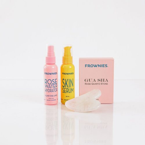 Frownies gua sha rose quartz stone next to Frownies Rose water hydrator spray and skin serum